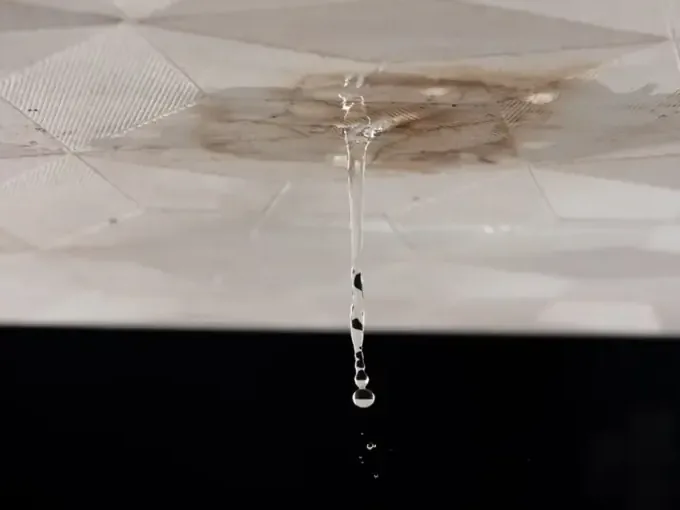 Water dripping from a stained ceiling after a leak above