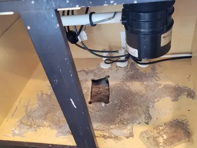 Sink cabinet floor opened below the plumbing after a pipe leak