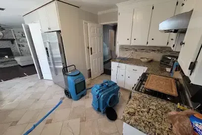 Dehumidifier and air mover running in a kitchen after a leak