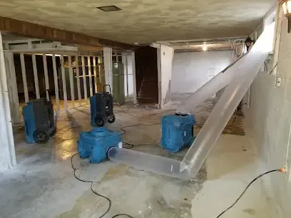 Air movers, dehumidifiers and poly ducting drying out a basement